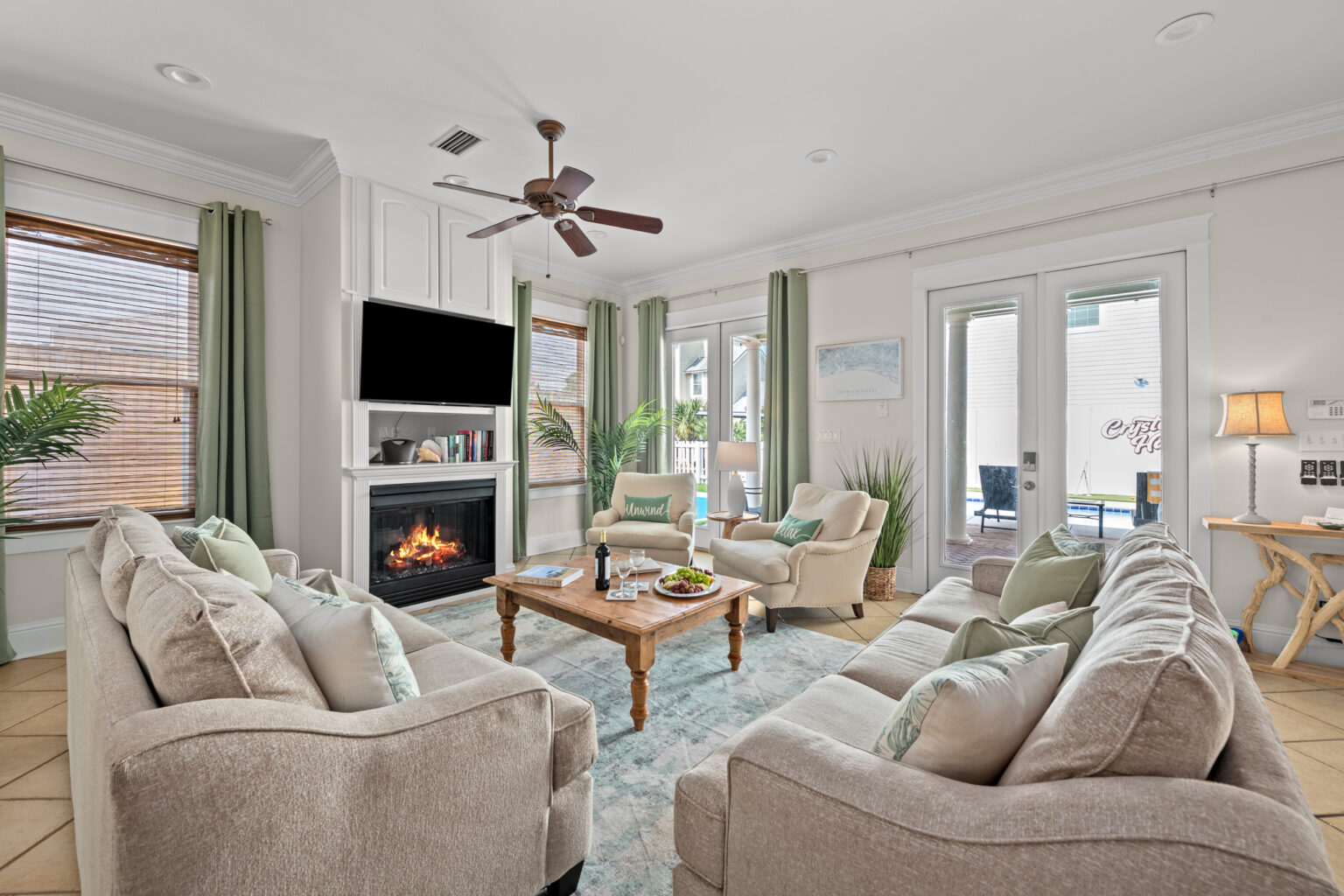 The living room at Crystal Haven, with the fireplace and doors out to the pool